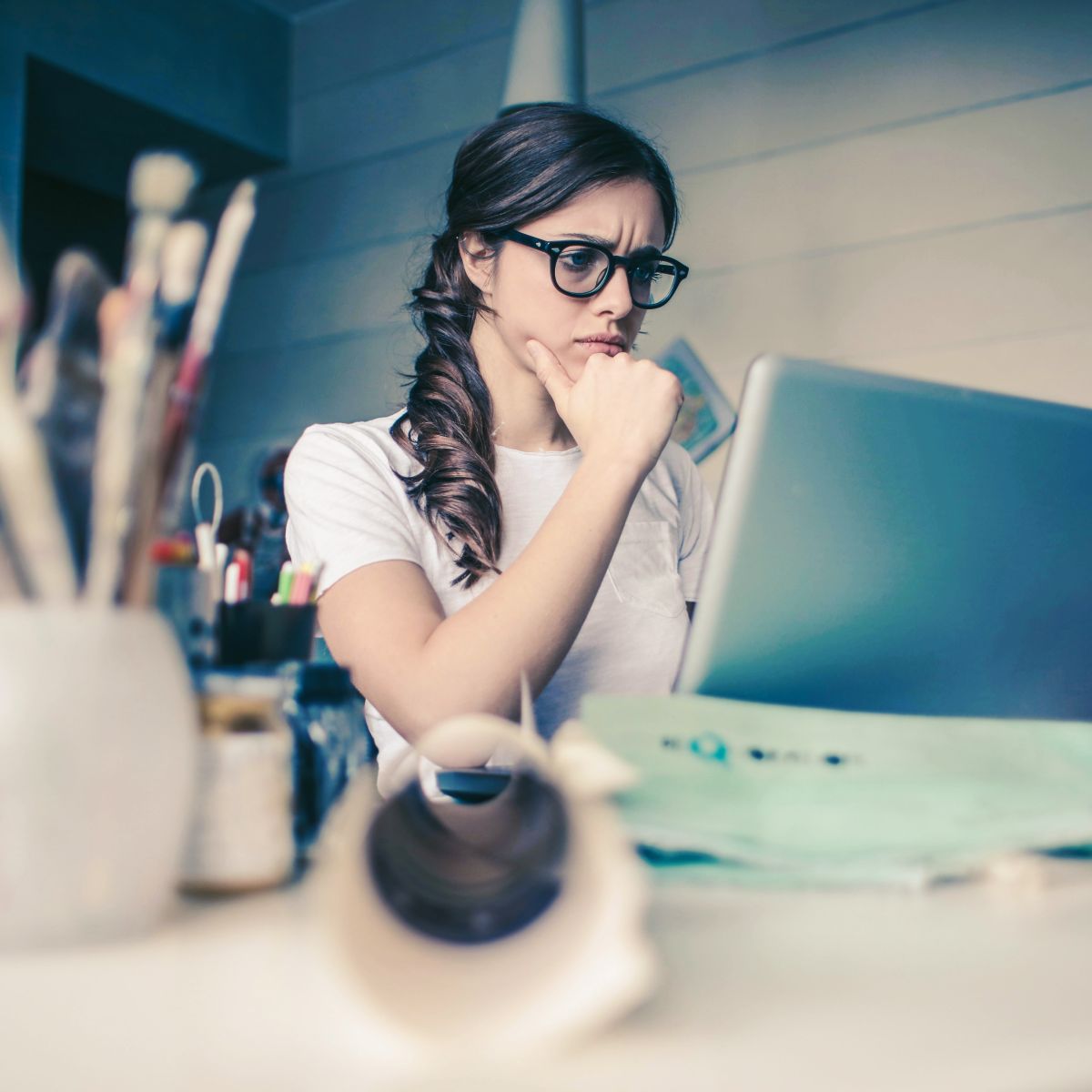woman sitting at desk looking at computer.