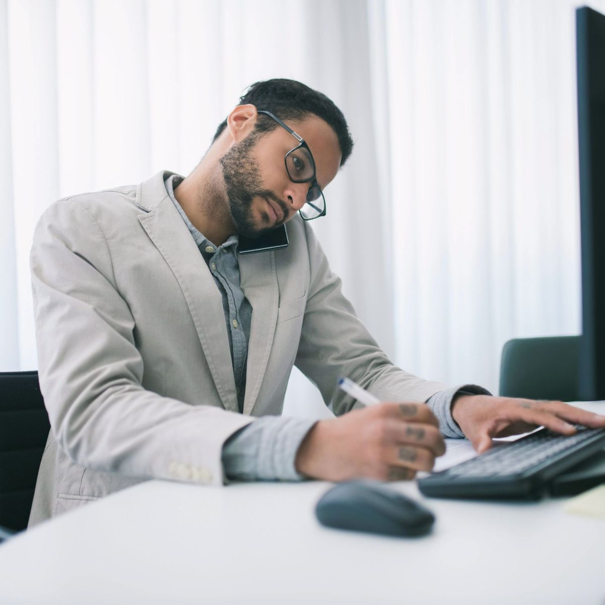 male business owner on phone looking at computer.