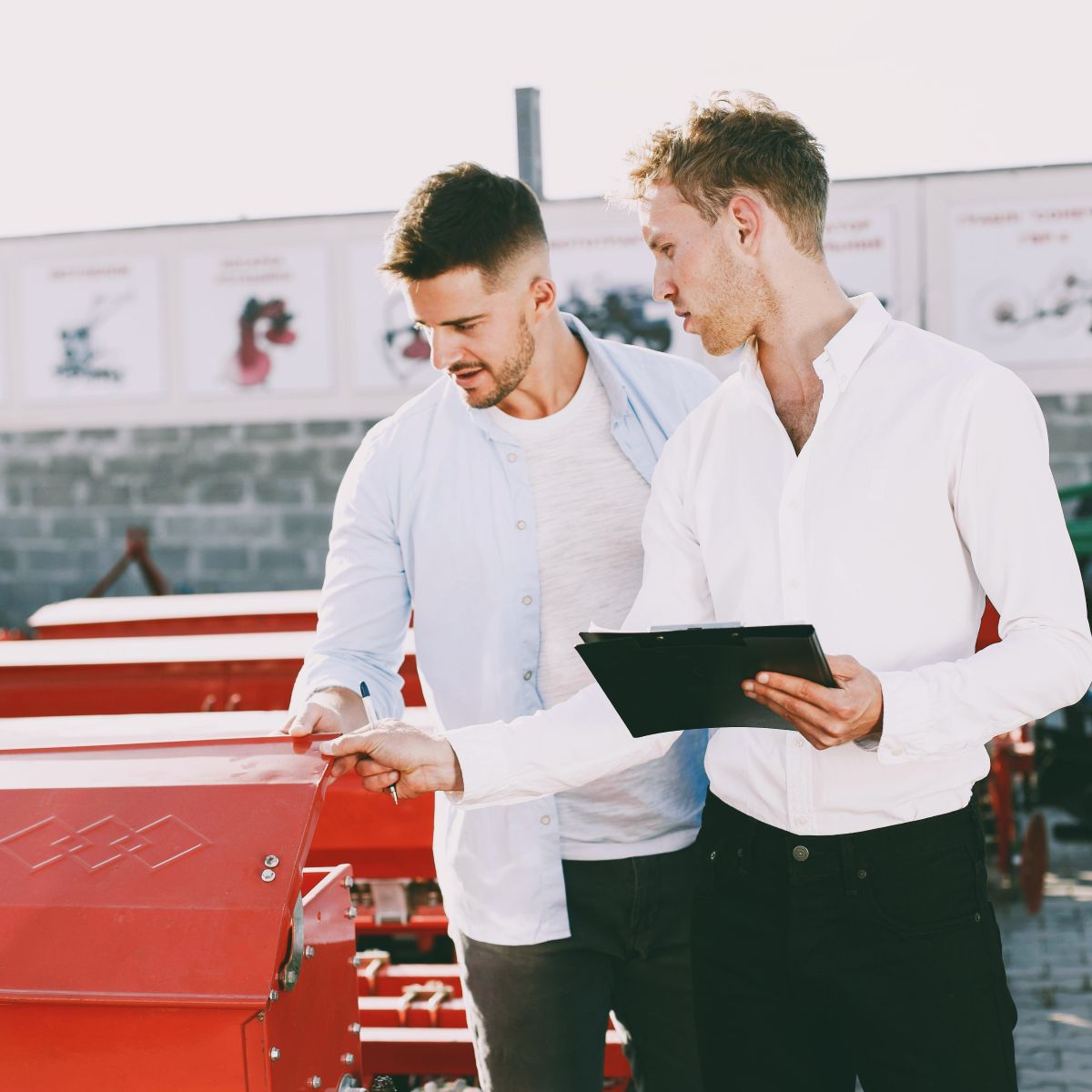 two professional men outside looking at equipment.
