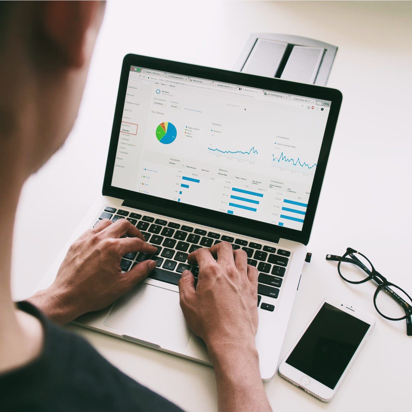 Marketer on computer with data dashboard.