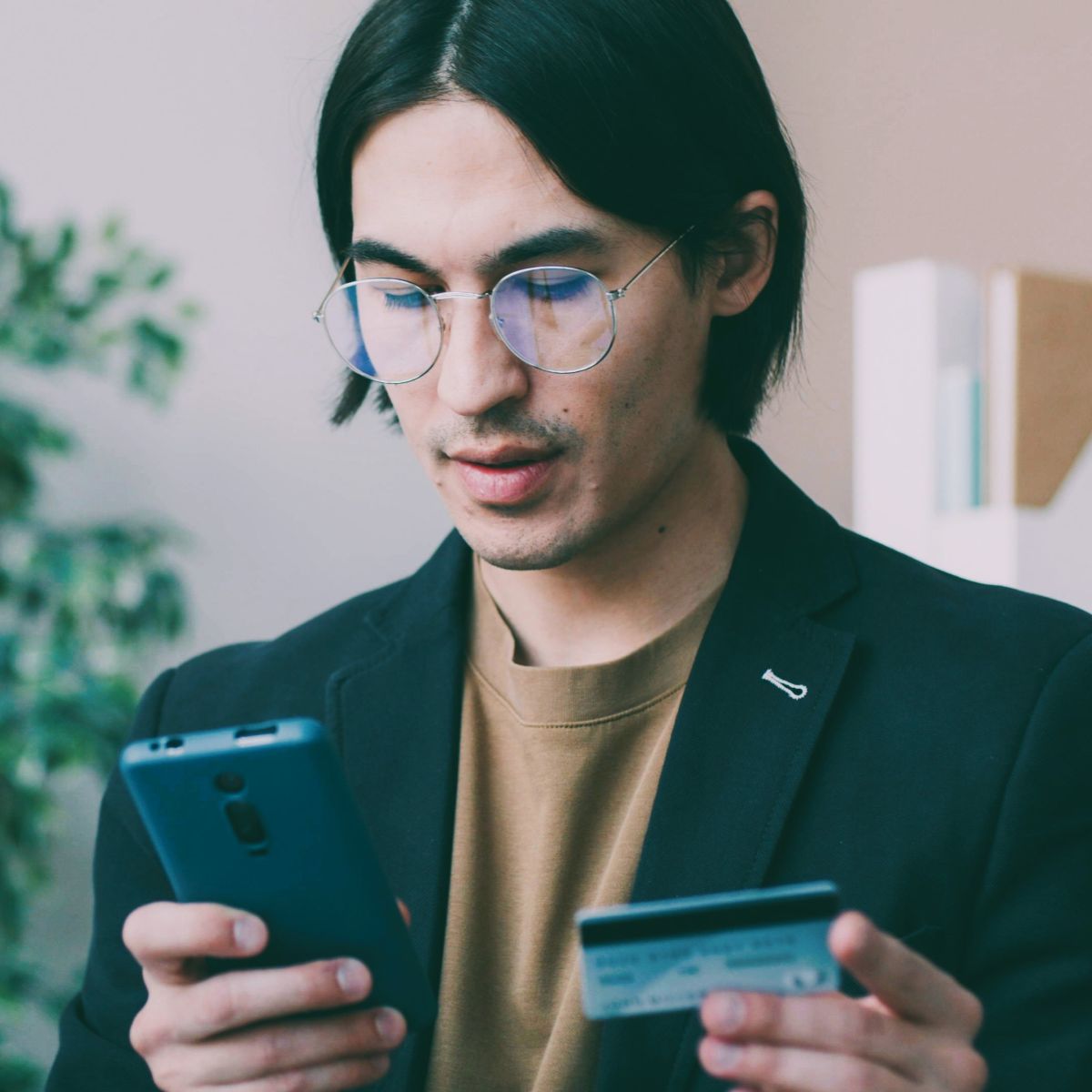man holding phone and credit card.