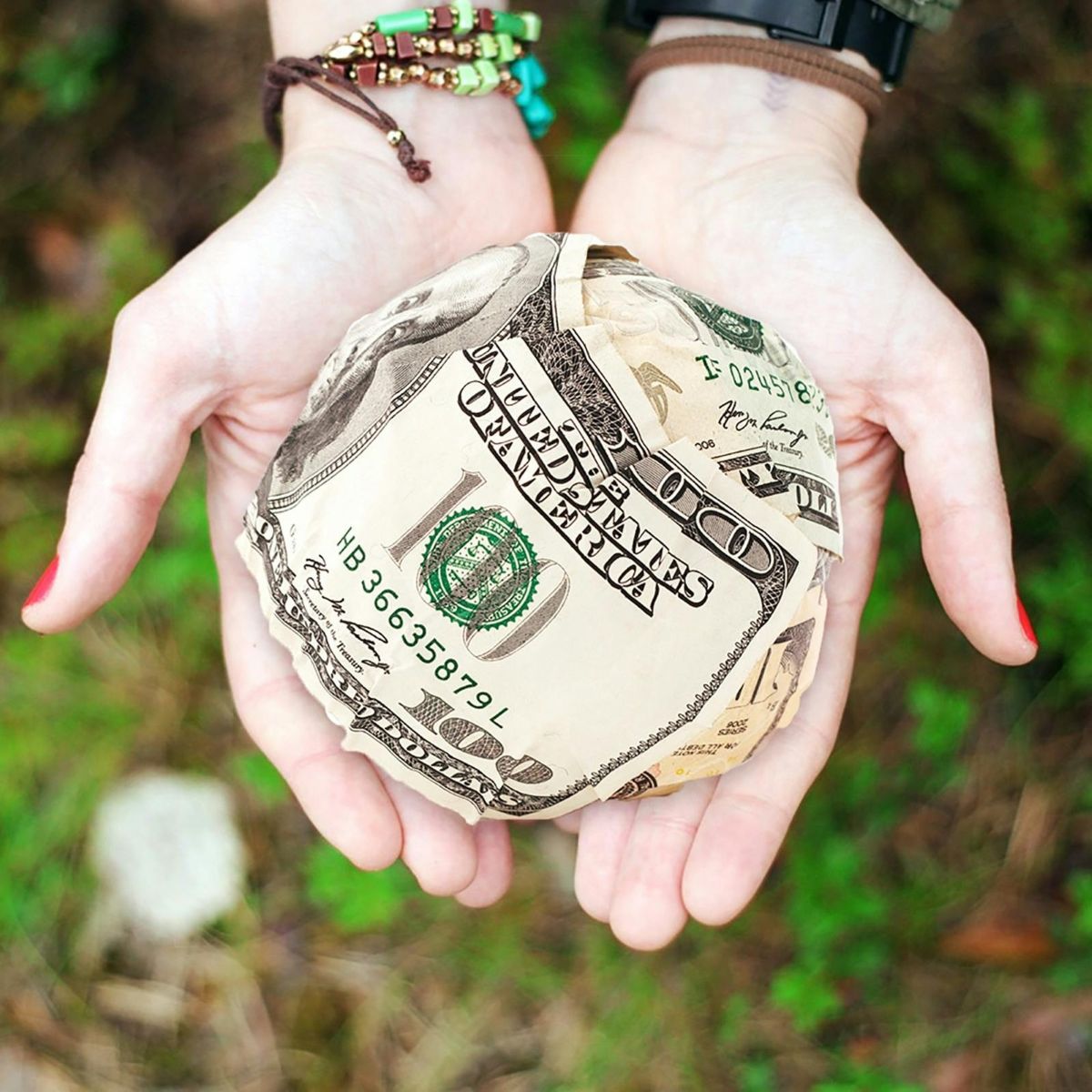 pexels-pixabay-271168_1200 Hands holding a ball of money.