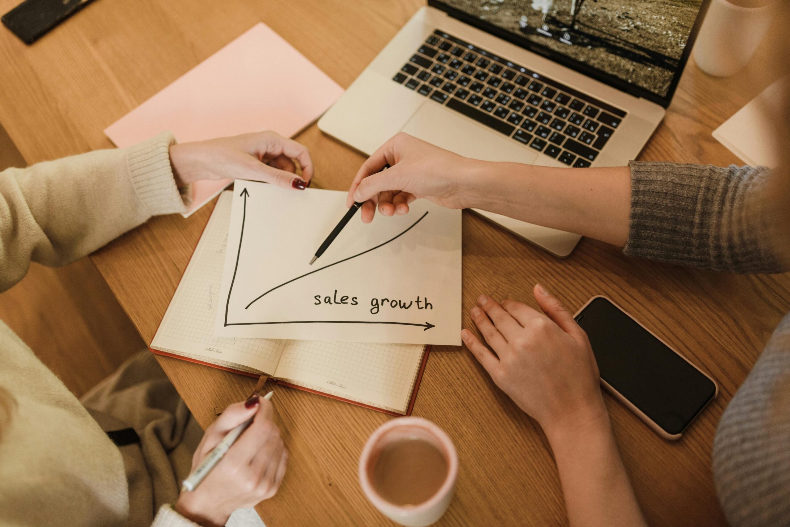 line graph on paper showing sales growth increase.